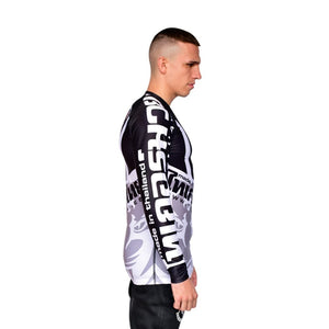 Camiseta deportiva Rash Guard de la marca "Tiger Muay Thai" de color blanco, gris y negro. Llevada por modelo con brazos estirados. Transpirable con diseño sublimado. Imagen perfil derecho.