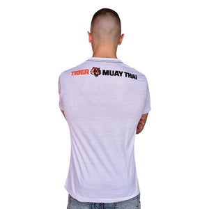 Camiseta "TMT" color blanco con diseño "EVOLUTION" llevada por modelo con brazos cruzados. Logo de la marca en la parte superior trasera.