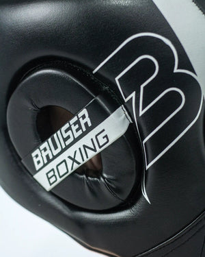 Enfoque detallado del lateral derecho del casco Bruiser negro. Logo de la marca y "Bruiser Boxing" escrito.