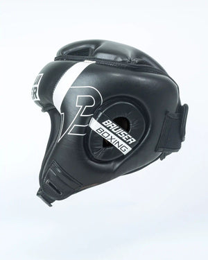Casco Bruiser color negro con detalles blancos. Logo en el centro de la frente en letras blancas. Rayas blancas en los lados superiores. Hecho de polipiel de alta calidad con acolchado interior denso. Perfil derecho.