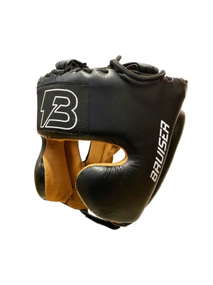 Casco de boxeo Bruiser color negro con logo en el centro. Hecho de cuero de alta calidad con relleno EVA. Interior de piel de melocotón. Perfil izquierdo.