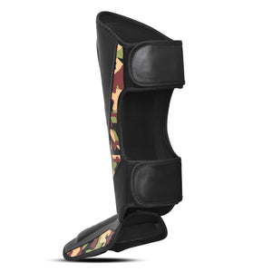 Perfil izquierdo espinillera de Muay Thai "Bruiser CAMO", diseño de camuflaje combinado con negro y dorado, logo Bruiser en la parte frontal, hecha de piel sintética resistente, protección para espinillas, tobillos y pies. Para Kickboxing, MMA y entrenamiento de contacto con ajuste de velcro seguro.