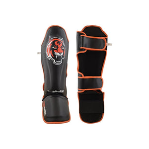 Espinilleras marca Tiger por delante y por detrás color negro y naranja. Hechas de piel sintética con neopreno en la zona tibial. Doble cierre de velcro.