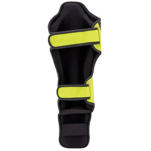 Espinillera marca Bruiser por detrás color amarillo. Hecha de microfibra y rellenas de espuma y latex. Cierres anchos de velcro.