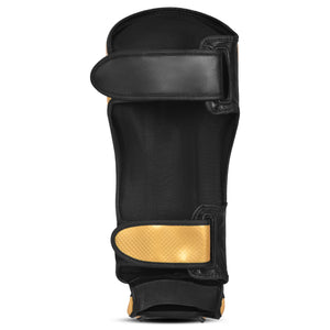 Espinillera marca Bruiser por detrás color negro y dorado. Hecha de microfibra y rellenas de espuma y latex. Cierres anchos de velcro.