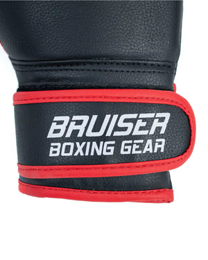 Enfoque detallado velcro guante Bruiser para niños color negro y rojo con detalles blancos. Logo en el centro. Hecho de polipiel con apoyo de goma espuma en la palma. Cierre de velcro ancho.