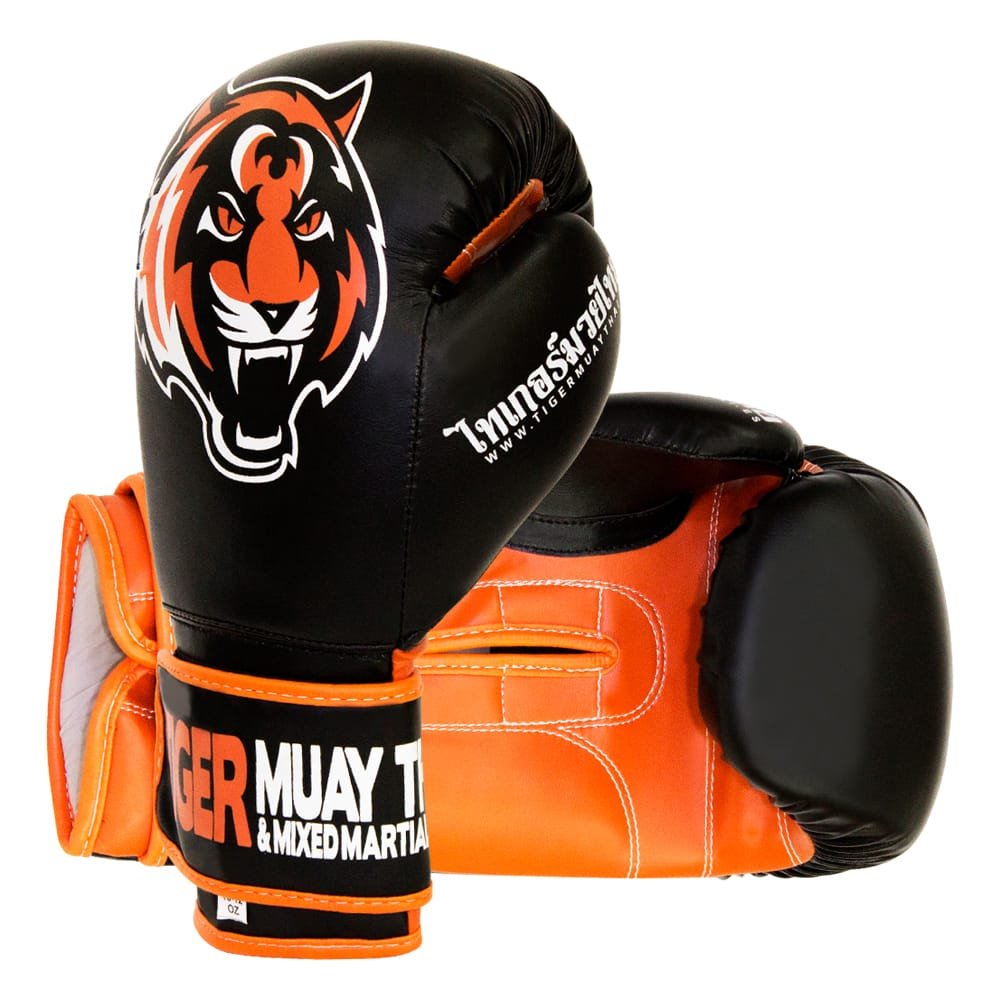Guantes de boxeo marca Tiger uno de pie y otro estirado color negro y naranja. Logo en el centro. Hechos de piel sintética con capas densas. Cierre de velcro rígido y cuerda interior para mejor sujeción.