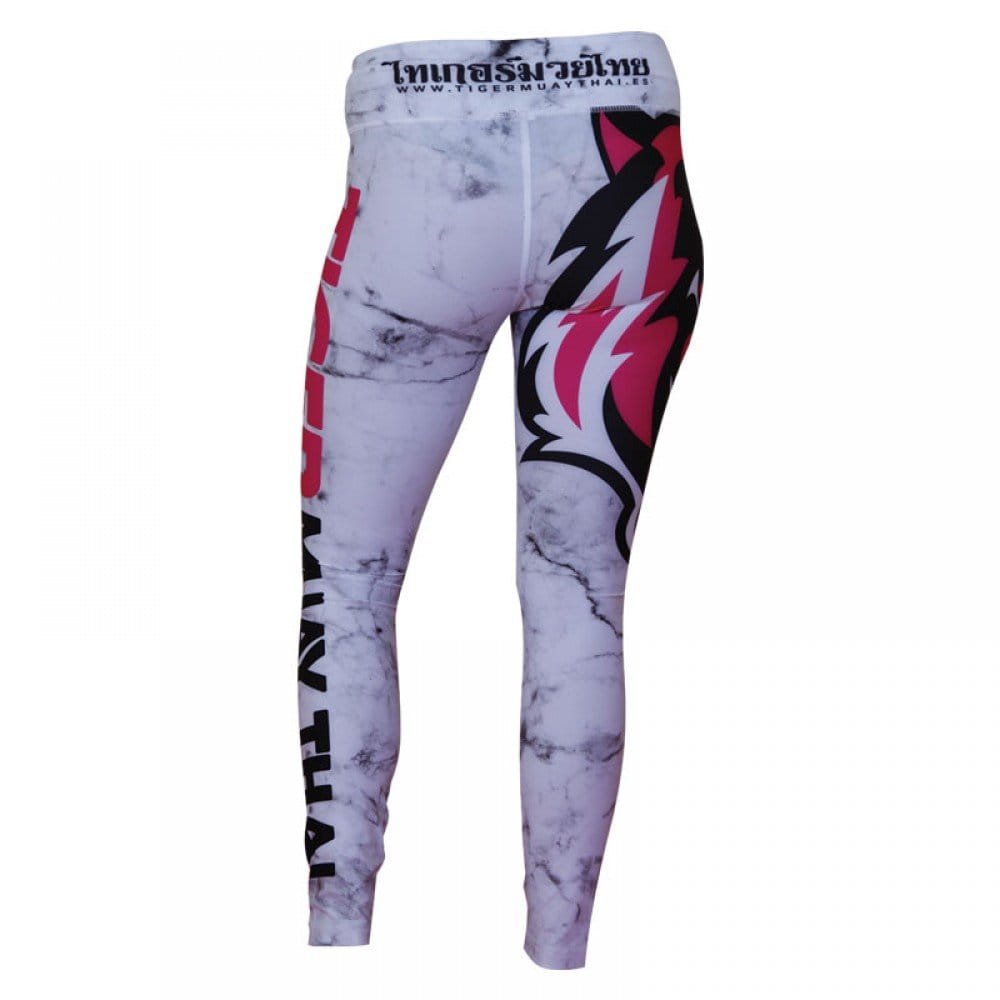 Mallas "TMT" por detrás color blanco con detalles negros y rosas. Logo en grande de color rosa en pierna derecha. Hechas de poliester y spandex. Cordón de ajuste de cintura.