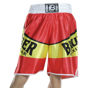 Pantalón deportivo de boxeo Bruiser color rojo, amarillo y blanco llevado por cintura de maniquí. Logo escrito "Bruiser" a los lados en letras negras y en la cinta superior. Hecho de poliester de alta calidad. Diseñado con corte ideal para la práctica de boxeo. Imagen frontal.