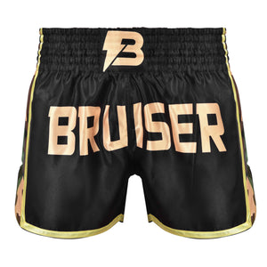 Short de Muay Thai "Bruiser" satén color negro con detalles dorados y diseño camuflaje. Logo en el centro y cintura elástica. Diseño camuflaje a los lados. Foto frontal.