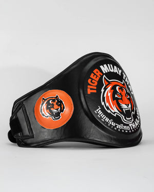 Ventral "TMT" color negro y naranja con logo en grande en la parte frontal. Hecho con materiales premium y relleno de alta densidad. Logo en los laterales. Ajuste cómodo y natural, velcro reforzado. Imagen lateral.