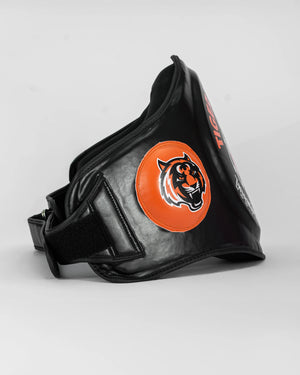 Ventral "TMT" color negro y naranja. Hecho con materiales premium y relleno de alta densidad. Logo en los laterales. Ajuste cómodo y natural, velcro reforzado. Imagen lateral.
