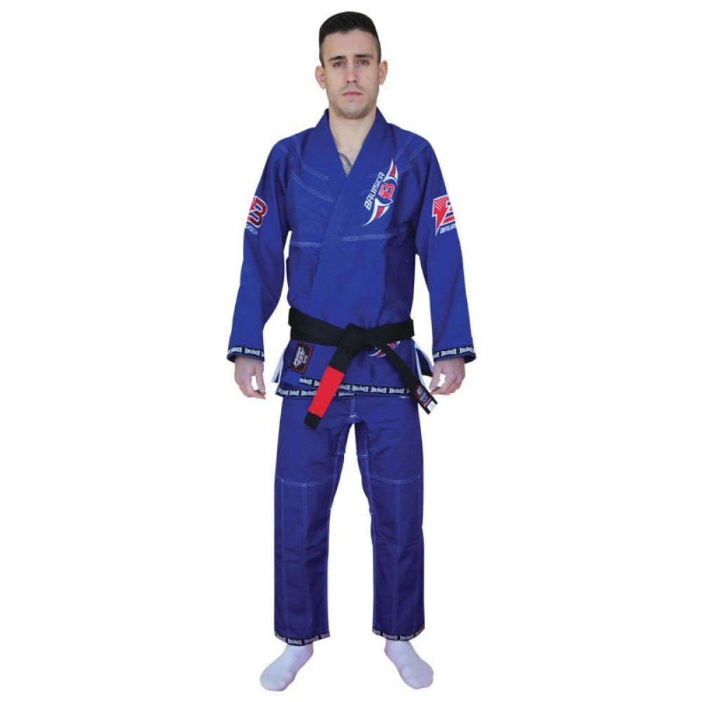 Kimono de Jiu Jitsu color azul con detalles rojos, llevado por modelo con brazos estirados y cinturón negro. Logo de "Bruiser" bordado en las dos mangas y en la parte izquierda superior. Hecho de 100% algodón, ajuste perfecto. Imagen frontal. 
