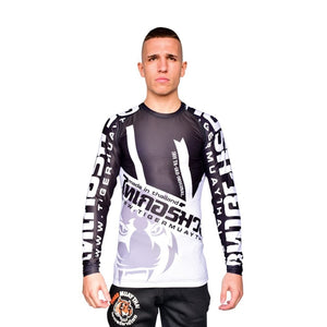 Camiseta deportiva Rash Guard de la marca "Tiger Muay Thai" de color blanco, gris y negro. Llevada por modelo con brazos estirados. Transpirable con diseño sublimado. Imagen frontal