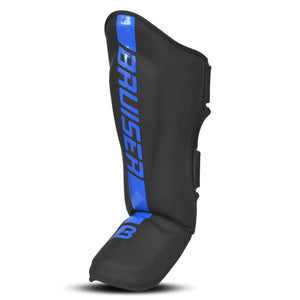 Espinillera marca Bruiser color negro y azul. Logo en el centro. Hechas de piel sintética y rellena de espuma y látex. Doble cierre de velcro. Perfil izquierdo.