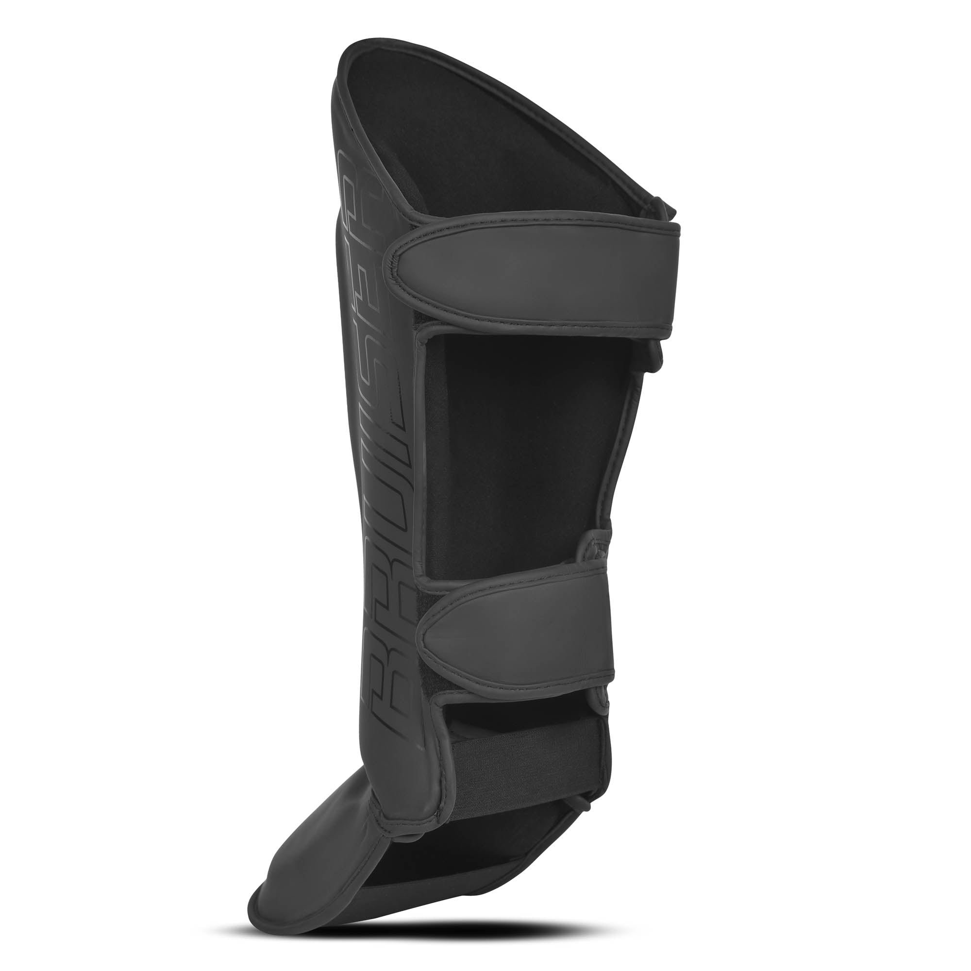 Espinillera marca Bruiser por detrás color negro.  Hechas de piel sintética y rellena de espuma y látex. Doble cierre de velcro. Perfil izquierdo. 