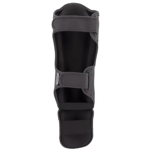 Espinillera marca Bruiser por detrás color negro. Hecha de microfibra y rellenas de espuma y latex. Cierres anchos de velcro. 
