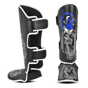 Espinilleras marca Tiger para niños por delante y por detrás color negro y azul. Logo en el centro. Hechas de polipiel con espuma absorbente. 