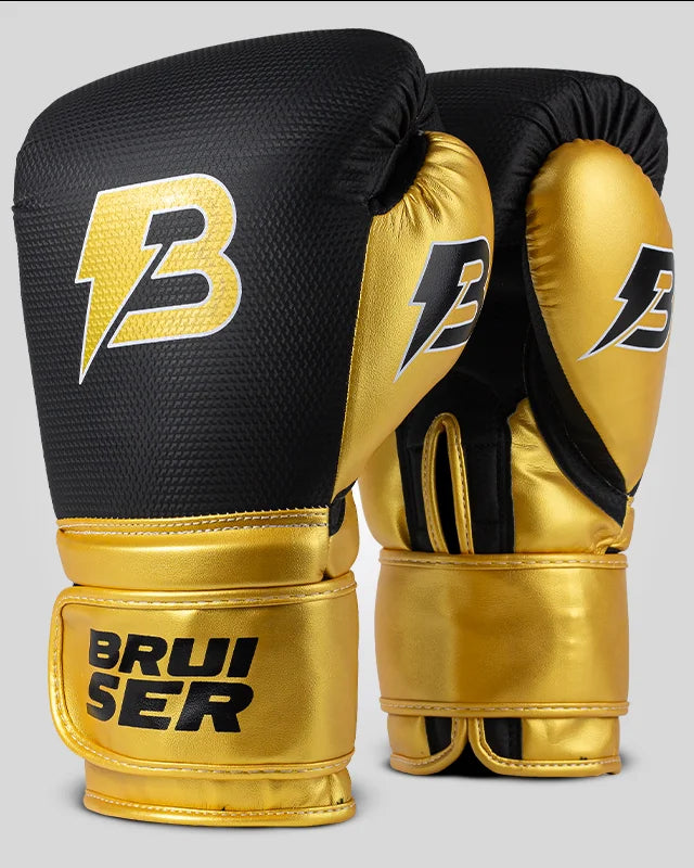 Par de guantes de boxeo negro y dorado con logo lateral, para muay thai y kick boxing con cierre velcro seguro. Imagen lateral.