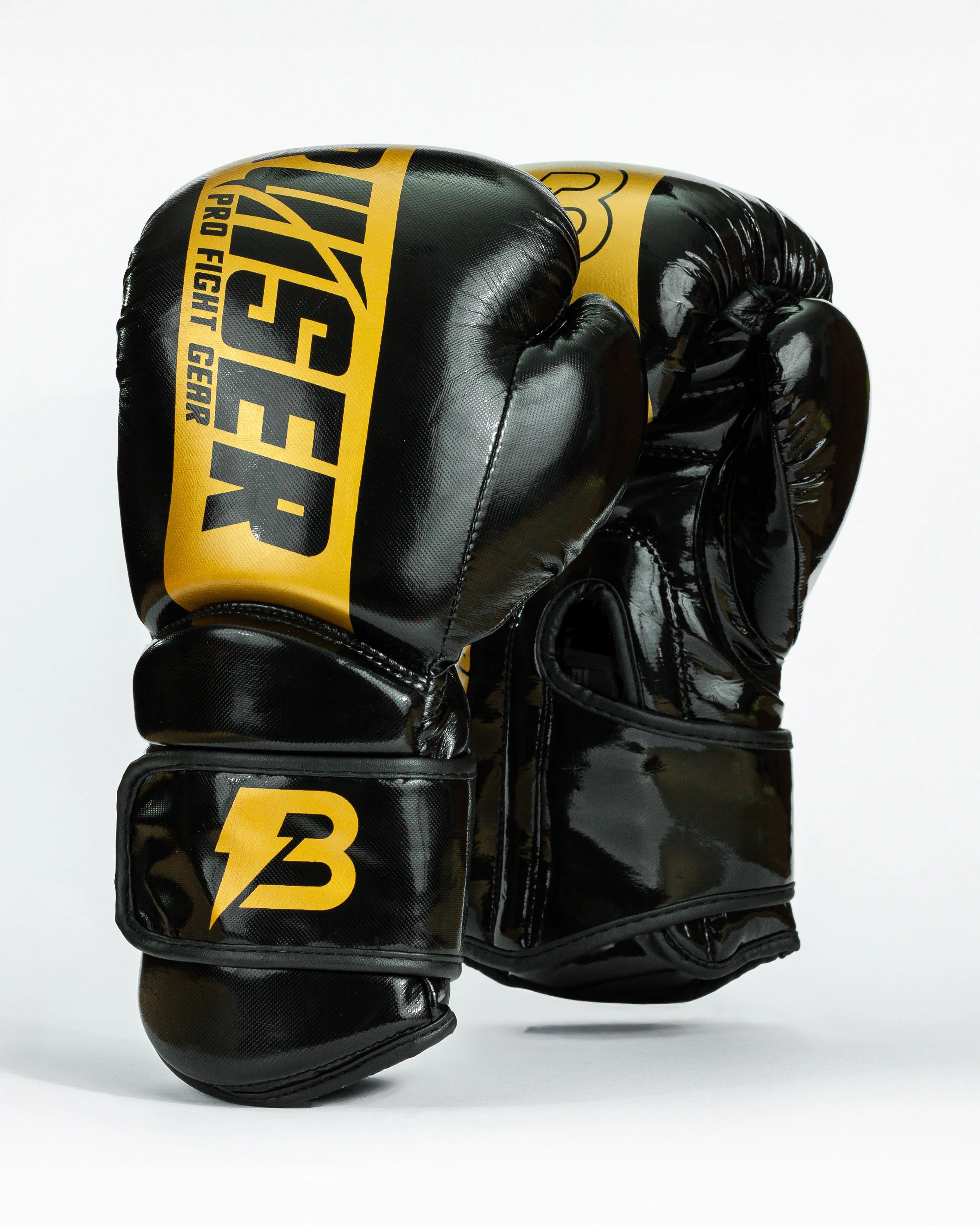 Guantes de boxeo Bruiser color negro y dorado. Logo de la marca en el centro en vertical. Hecho de polipiel resistente con acolchado interior. Cierre de velcro seguro. Para entrenamiento en saco y sparring controlado. 