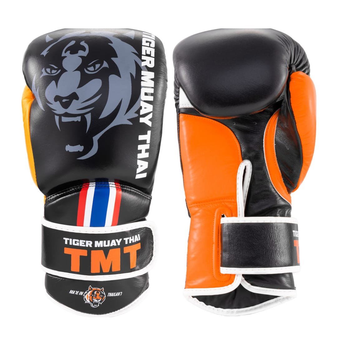 Guantes de Muay Thai marca Tiger por delante y por detras color negro y naranja. Logo Tiger en el centro. Hechos de piel de vaca con relleno en Flex. Velcro seguro. Imagen frontal. 