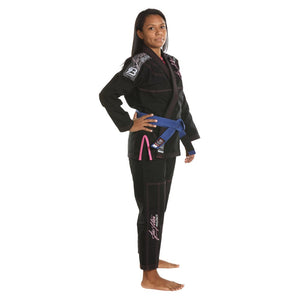 Kimono de Jiu Jitsu para mujer marca Bruiser color negro con detalles rosas. Llevado por modelo con mano en la cintura mirando al frente. Hecho de algodón con costuras reforzadas y tejido doble capa. Perfil derecho.