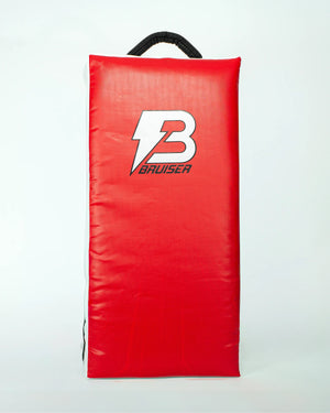 Pao escudo gigante "Bruiser" rojo con detalles blancos y negros. Logo en el centro en color blanco. Hecho de materiales de alta calidad con relleno de alta densidad. Para Boxeo, Muay Thai, Karate, Taekwondo, Kickboxing. Imagen frontal.