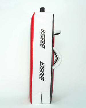 Pao escudo gigante "Bruiser" rojo con detalles blancos y negros. Hecho de materiales de alta calidad con relleno de alta densidad. "Bruiser" escrito en los laterales. Agarres reforzados. Para Boxeo, Muay Thai, Karate, Taekwondo, Kickboxing. Perfil izquierdo.