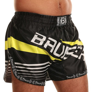 Pantalón deportivo Bruiser para Muay Thai color negro con detalles amarillos y logo "Bruiser" escrito en el centro de color blanco, llevado por modelo de cintura. 100% poliéster, experiencia ligera. Cinturón elástico con costuras reforzadas. Imagen perfil derecho.