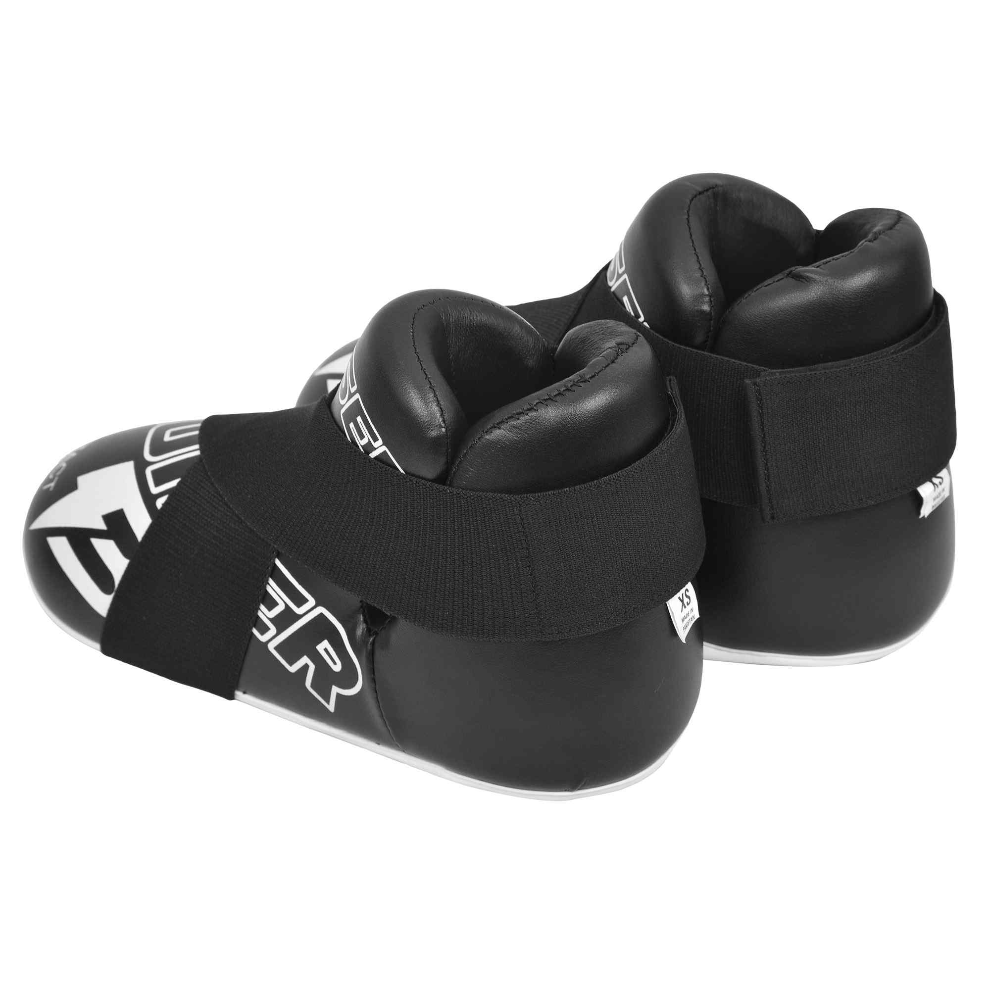 Protectores de pie "Bruiser" color negro para kickboxing, taekwondo o muay thai uno encima del otro. Hechos de polipiel. Sistema de sujeción con elástico y cierre de velcro. Parte trasera.