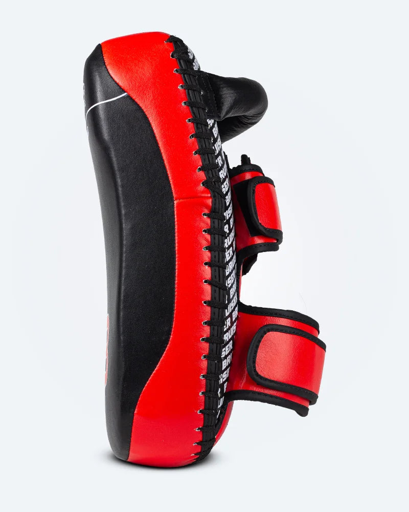 Lateral de Pao Bruiser color negro y rojo. Hecho de cuero y micro fibra con espuma inteligente. Para Karate, Muay Thai, Jiu Jitsu, Kickboxing. Perfil izquierdo.