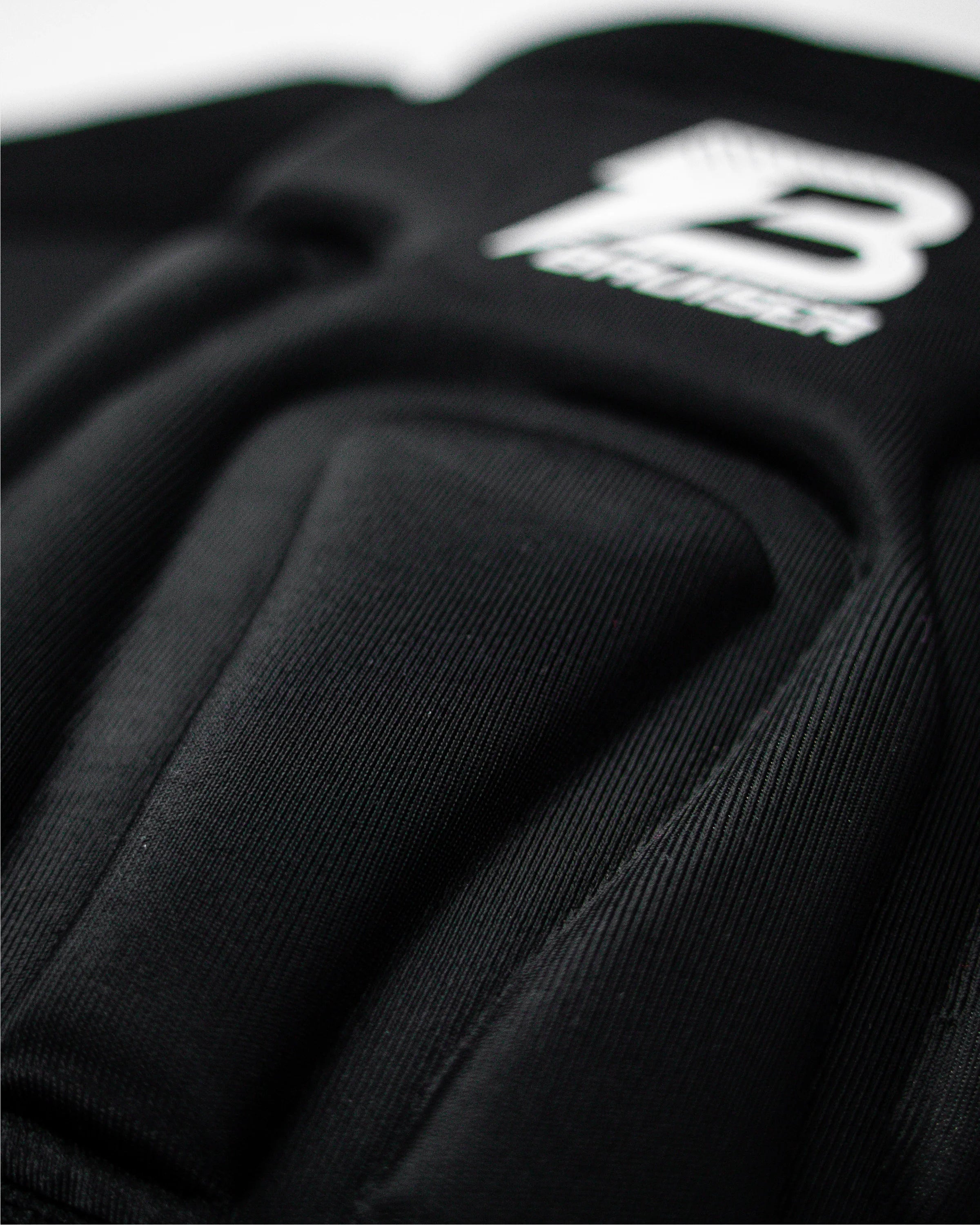 Enfoque detallado rodilleras Bruiser color negro con logo ligeramente borroso. 