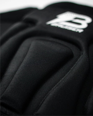 Enfoque detallado rodilleras Bruiser color negro con logo ligeramente borroso. 
