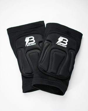 Par de rodilleras Bruiser de color negro estiradas una encima de otra. Logo en el centro. Protección, comodidad y libertad de movimiento seguras. Para sparring, BJJ y MMA. Imagen frontal.