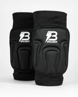 Par de rodilleras Bruiser de color negro. Una detrás de otra. Logo en el centro. Protección, comodidad y libertad de movimiento seguras. Para sparring, BJJ y MMA. Imagen frontal.