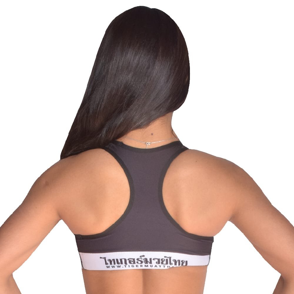 Sujetador marca TMT para fitness para chicas color negro y blanco por detrás. Hecho de poliester y spandex. 