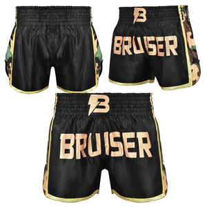 Short de Muay Thai "Bruiser" satén color negro con detalles dorados y diseño camuflaje. Logo en el centro y cintura elástica. Diseño camuflaje a los lados. Foto frontal y trasera. 