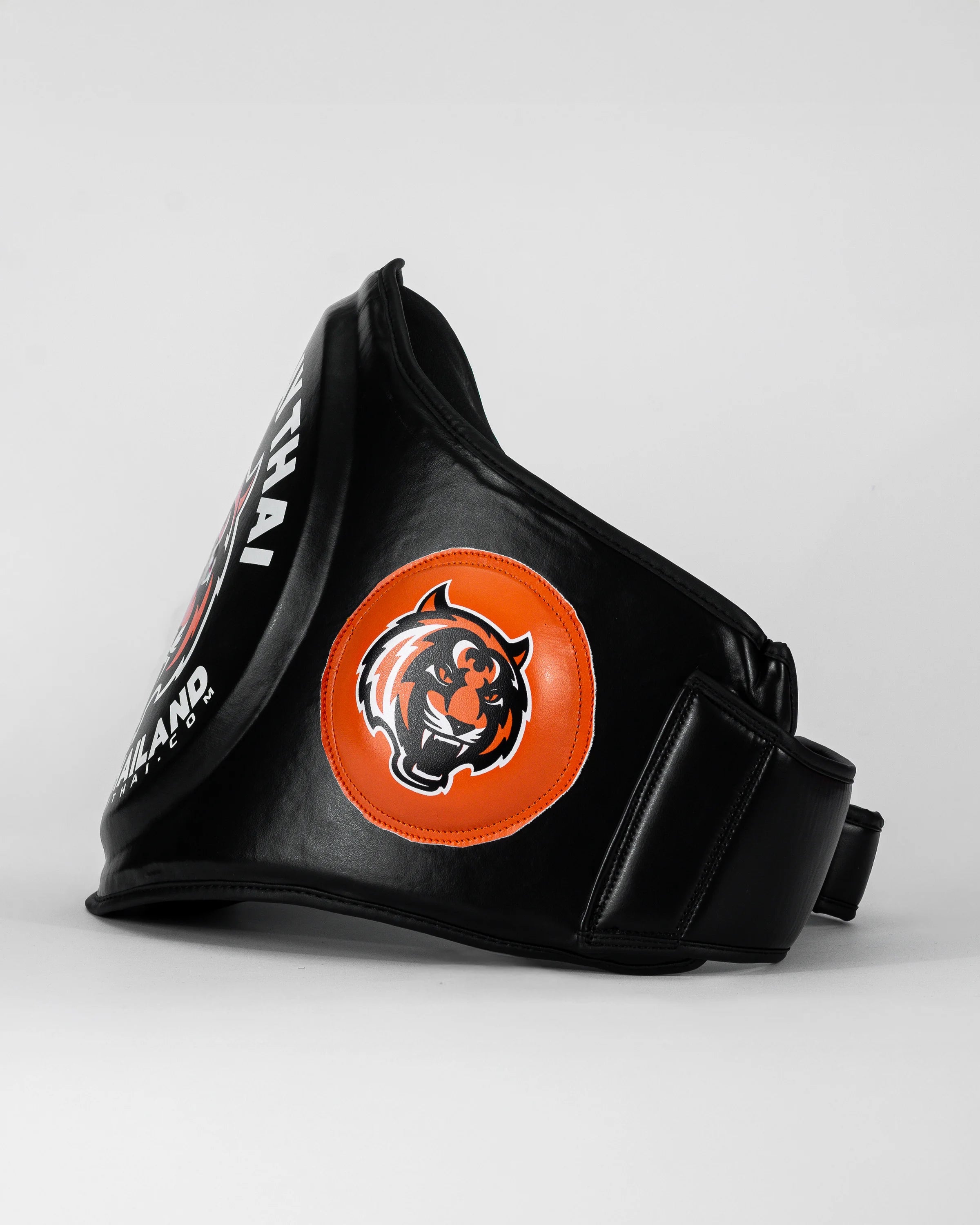 Ventral "TMT" color negro y naranja. Hecho con materiales premium y relleno de alta densidad. Logo en los laterales. Ajuste cómodo y natural, velcro reforzado. Imagen lateral.  